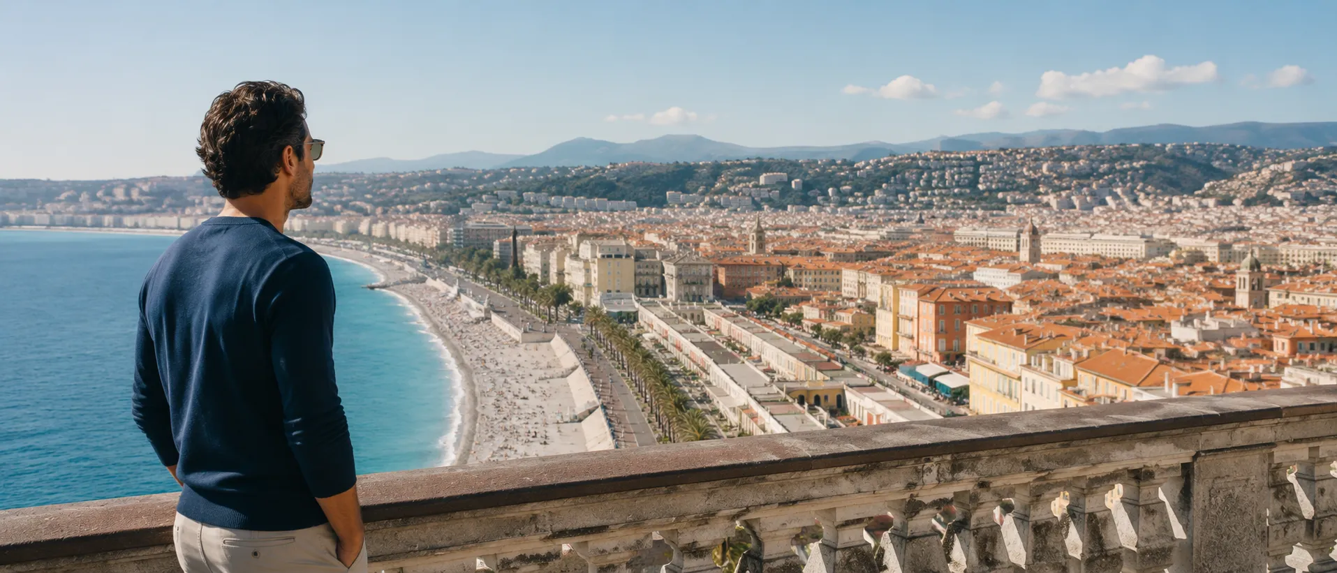 Un homme contemple la baie des Anges et la ville de Nice depuis les hauteurs, sur la Côte d'Azur